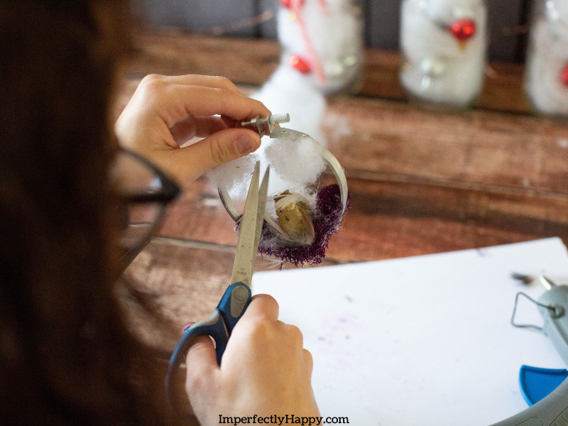 DIY Ornament - woman using scissors to finish project.
