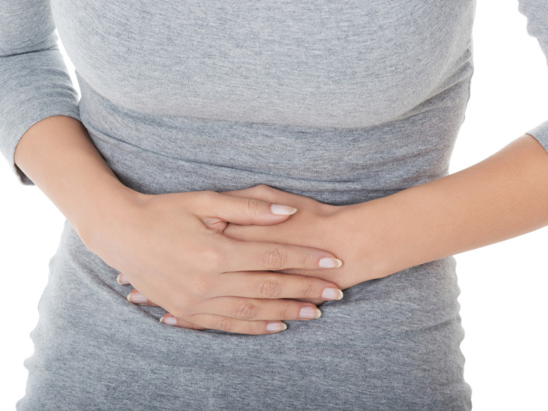 Home remedies for an upset stomach. Woman holding tummy in pain.