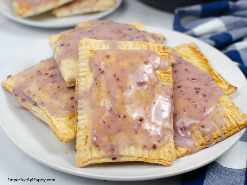 homemade pop tarts recipe baked and ready to eat on white plate with blue checkered napkin.