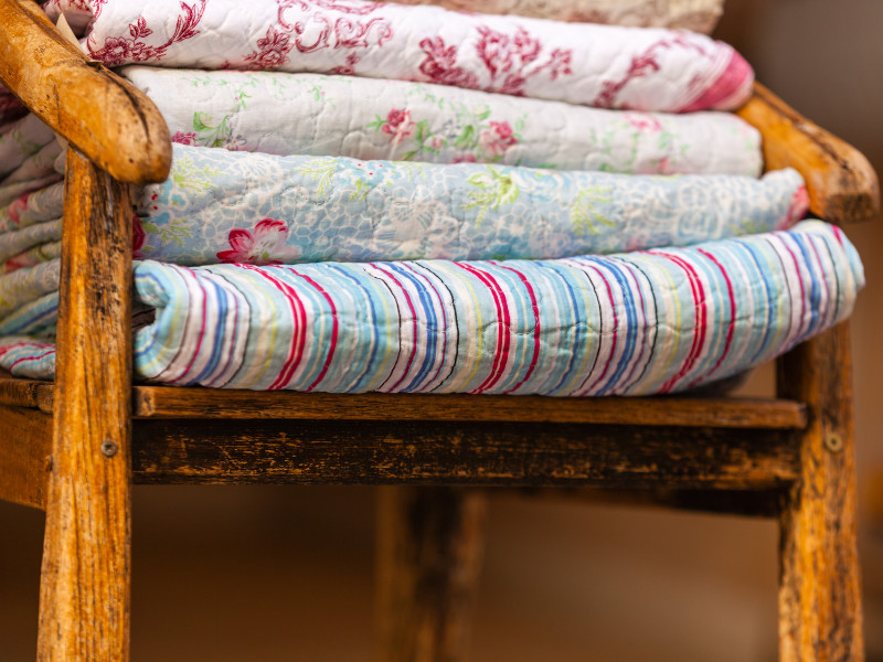 How to store blankets for emergencies - pile of blankets on a wooden chair